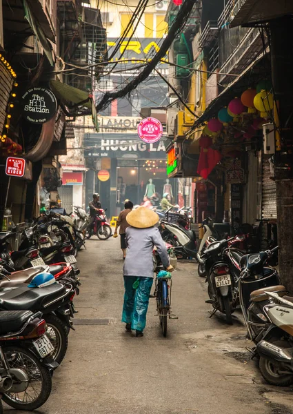  Kimliği belirsiz bir kadın, Hanoi, Vietnam 'da bisiklet sürüyor.