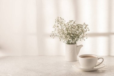 Kahve ve bir buket çigila beyaz bir masada. Kadın masası. Sıcak kahvaltı..