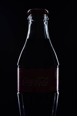  Siyah arka planda cam Coca Cola şişesi.