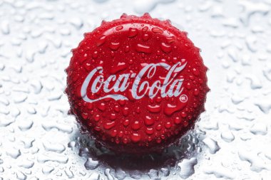 Klasik Coca-Cola kapağı yakın plan gri zemin üzerinde su damlaları ile.