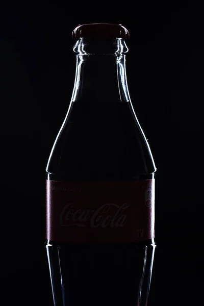 Glass bottle of coca cola on black background close-up — Stock Photo, Image