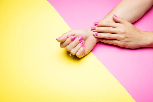 Manicure rosa elegante em um fundo amarelo e rosa — Fotografia de Stock
