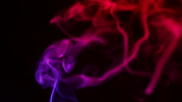 Multicolored smoke from aromatic sticks close up on black background — Stockvideo