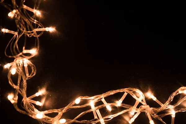 Kerstlichtgrens. Kerstachtergrond met verlichting en vrije tekstruimte. Kerstverlichting op zwarte achtergrond. Nieuwjaar. — Stockfoto