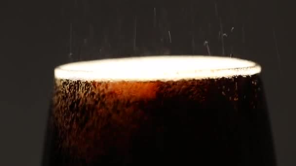 La mousse de bière se déverse sur le bord dans un gros plan de boulangerie. Fond noir isolé. — Video