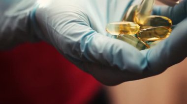 Tıbbi eldivenli kadın eli, tablet kapaklı.