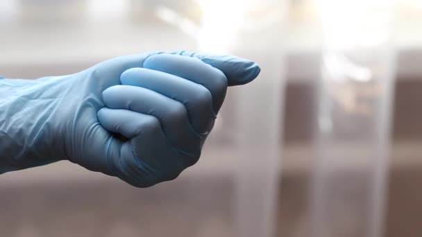 Weibliche Hand in medizinischem Handschuh mit einer Tablette Nahaufnahme — Stockvideo