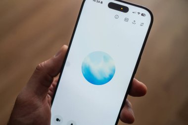 Kyiv, Ukrayna - 11 Eylül 2025: ChatGPT uygulama arayüzü ile el ele tutuşmak, mavi dairesel bir simge göstermek, yapay zeka ve dijital iletişimi sembolize etmek.