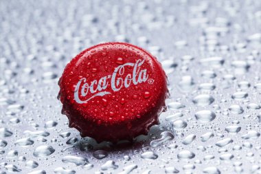 Klasik Coca-Cola kapağı yakın plan gri zemin üzerinde su damlaları ile.