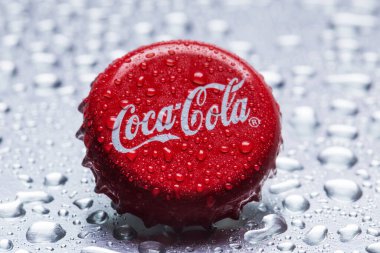Klasik Coca-Cola kapağı yakın plan gri zemin üzerinde su damlaları ile.