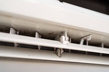 Havalandırmada görünür toz ve küf olan kirli bir klimanın yakın plan görüntüsü bakımsızlığı, sağlık risklerini ve temizlik ihtiyacını temsil ediyor..