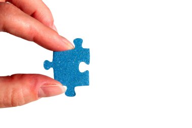 Yapboz parçasını tutan bir el. Mavi yapboz parçalı dişi parmaklar..