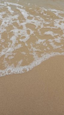 Kumsalda köpüklü beyaz okyanus dalgaları