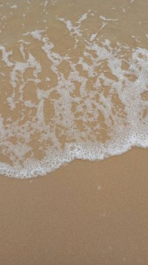 Kumsalda köpüklü beyaz okyanus dalgaları