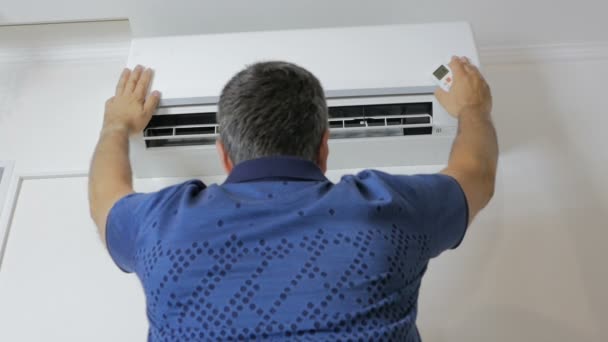 The man stands under the running air-conditioner and cools — Stock Footage The man stands under the running air-conditioner and cools Stock Footage