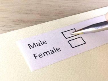 Bir kişi bir kağıt parçasındaki soruya cevap veriyor. Kişi cinsiyetini seçiyor..