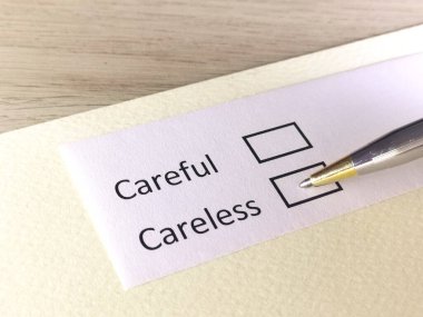 Bir kişi bir kağıt parçasındaki soruya cevap veriyor. Kişi dikkatli ya da dikkatsiz olmayı düşünüyor..