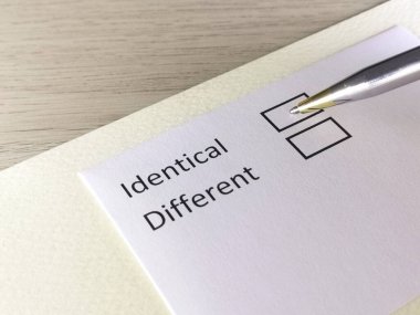 Bir kişi bir kağıt parçasındaki soruya cevap veriyor. Bu kişi aynı ya da farklı olduğunu düşünüyor..