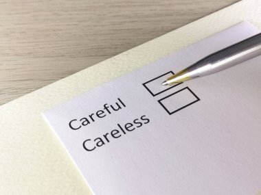 Bir kişi bir kağıt parçasındaki soruya cevap veriyor. Kişi dikkatli ya da dikkatsiz olmayı düşünüyor..