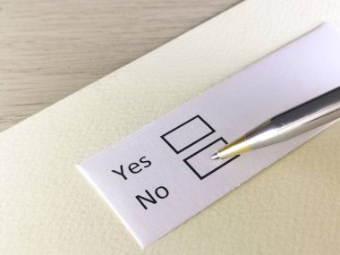 Bir kişi bir kağıt parçasındaki soruya cevap veriyor. Kişi evet ya da hayır demeyi düşünüyor..