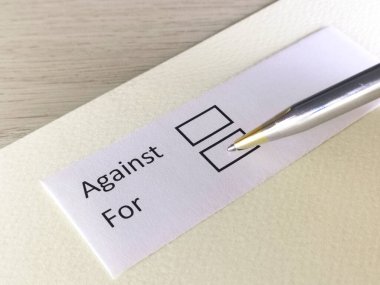 Bir kişi bir kağıt parçasındaki soruya cevap veriyor. Bu kişi karşı ya da lehine karar vermeyi düşünüyor..