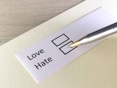 Bir kişi bir kağıt parçasındaki soruya cevap veriyor. İnsan aşkı ya da nefreti seçmeyi düşünüyor..