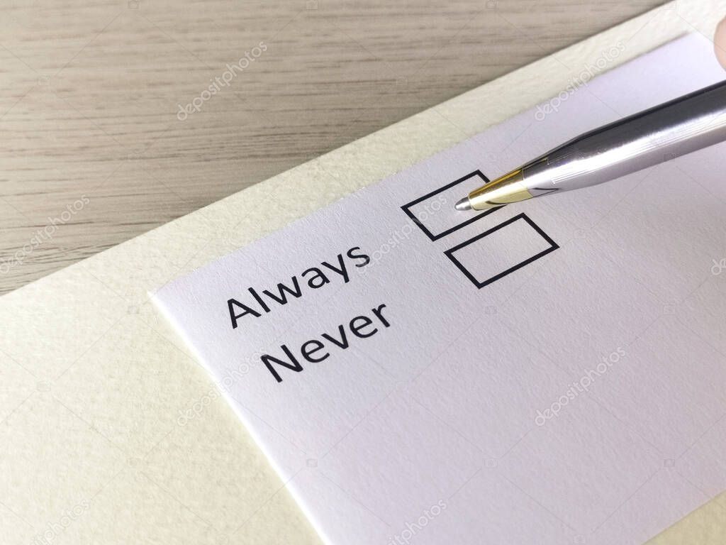 One person is answering question on a piece of paper. The person is thinking to be always or never.