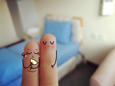 Two fingers are decorated as two person. One of them is crying in pain. The person just had an operation. clipart
