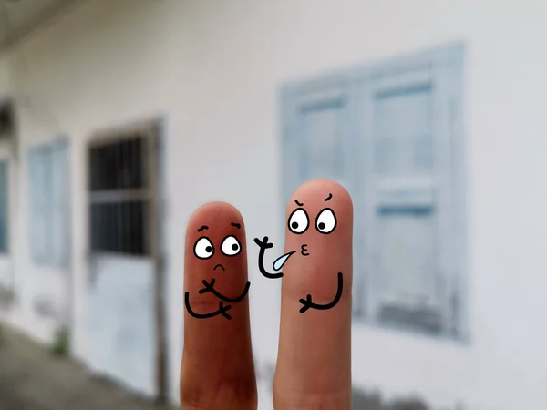 两个手指装饰成两个人 它们有不同的皮肤颜色 其中一个是吐口水给另一个人 — 图库照片