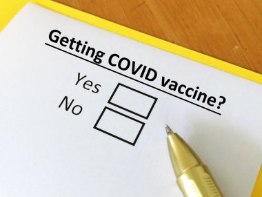 Bir kişi soruya cevap veriyor. Koronavirüs aşısı yaptırıp yaptırmadığını düşünüyor. Evet ya da hayır diyor..