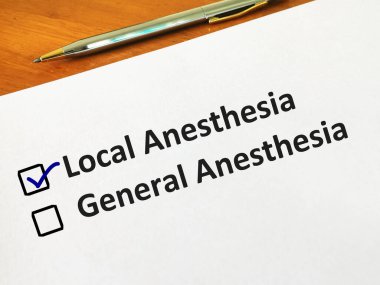 Bir kişi soruya cevap veriyor. Yerel ve genel anestezi arasında seçim yapıyor..
