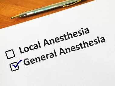 Bir kişi soruya cevap veriyor. Yerel ve genel anestezi arasında seçim yapıyor..
