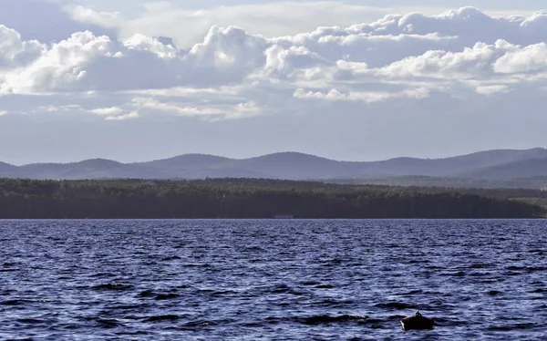 Gölün güzel tüylü ve cumulonimbus bulutlar ile üzerinde mavi gökyüzü görünümü güneşli bir günde, Güney Urallar, göl Uvildy