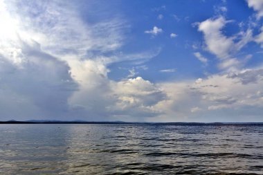 uzakta görünümünü ile güzel göl üzerinde mavi gökyüzü tüylü ve cumulonimbus bulutları güneşli bir günde, Ural Dağları görebilirsiniz