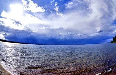 fırtına öncesi sessizlik gölün üzerinde koyu mavi gökyüzü, Güneş parlıyor