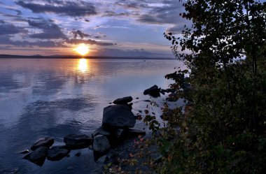 akşam gökyüzü göl güneş tarafından aydınlatılmış bulutlar siluetleri üzerinde