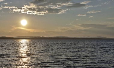 akşam gökyüzü göl güneş tarafından aydınlatılmış bulutlar siluetleri üzerinde