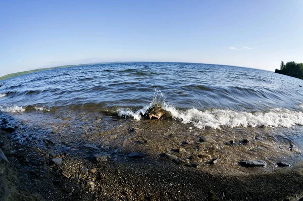 波が荒れて湖の岸を走る晴れた朝一番下の地点から — ストック写真
