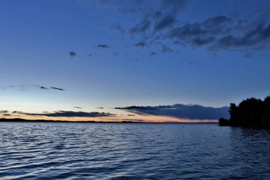 akşam gökyüzü göl güneş tarafından aydınlatılmış bulutlar siluetleri üzerinde
