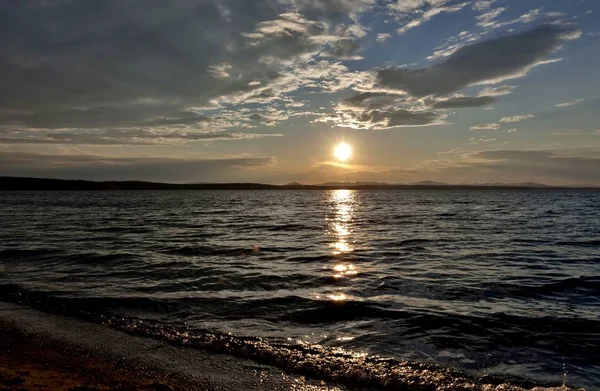 göl, turuncu güneşin üzerinde koyu gri akşam gökyüzü