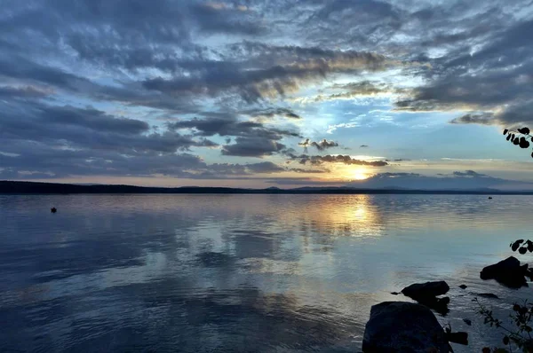 akşam gökyüzü göl güneş tarafından aydınlatılmış bulutlar siluetleri üzerinde