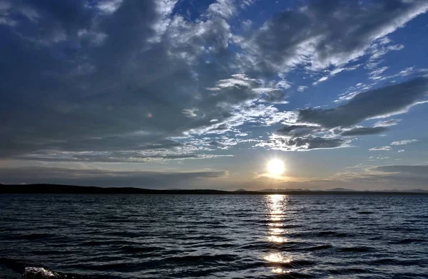 akşam gökyüzü göl güneş tarafından aydınlatılmış bulutlar siluetleri üzerinde