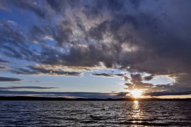 akşam gökyüzü göl güneş tarafından aydınlatılmış bulutlar siluetleri üzerinde