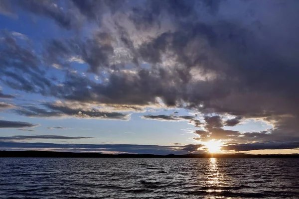 akşam gökyüzü göl güneş tarafından aydınlatılmış bulutlar siluetleri üzerinde
