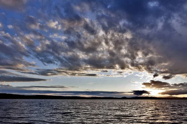 akşam gökyüzü göl güneş tarafından aydınlatılmış bulutlar siluetleri üzerinde
