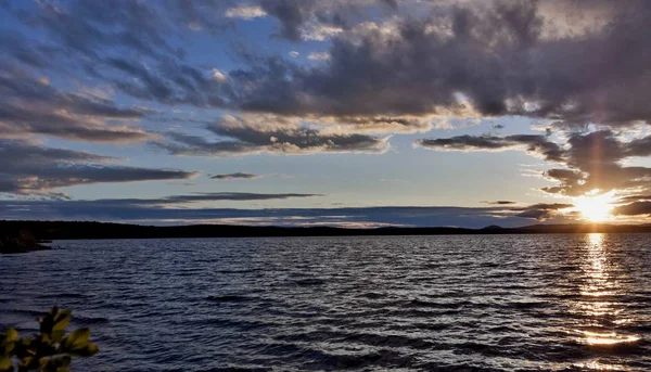 akşam gökyüzü göl güneş tarafından aydınlatılmış bulutlar siluetleri üzerinde