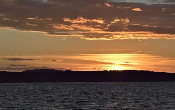 Altın güneş göl üzerinde akşam batar.