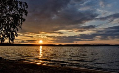 Altın güneş göl üzerinde akşam batar.