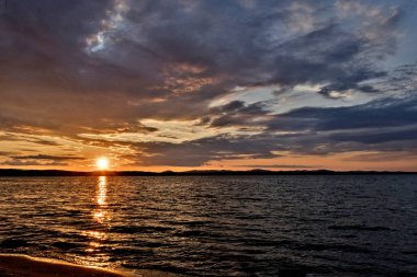 Altın güneş göl üzerinde akşam batar.