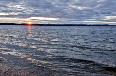 akşam gökyüzü göl güneş tarafından aydınlatılmış bulutlar siluetleri üzerinde